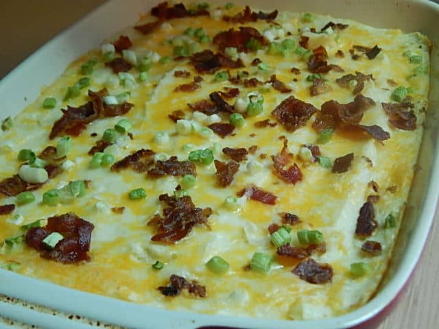 Loaded baked potato casserole in red baking dish