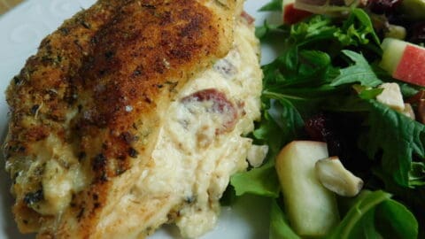 Cheese stuffed chicken breast on white plate