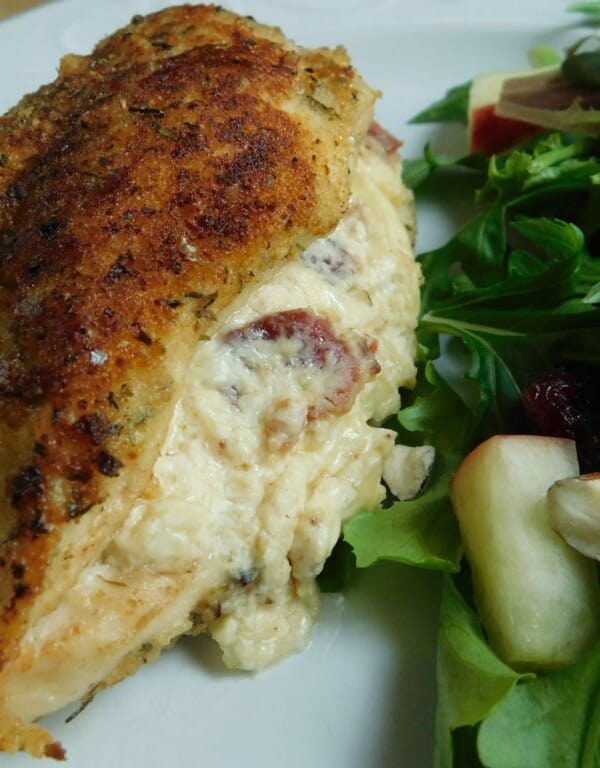 Cheese stuffed chicken breast on white plate