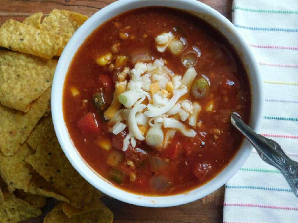 slow cooker chicken taco soup in a bowl with tortilla chips