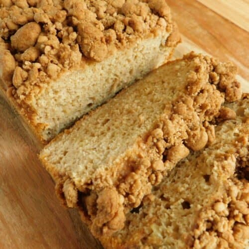banana bread with crumble topping sliced on cutting board