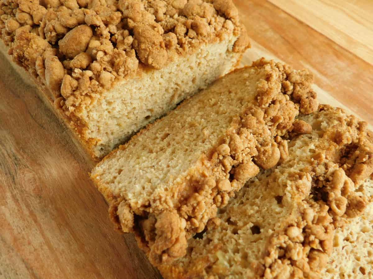 banana bread with crumble topping sliced on cutting board