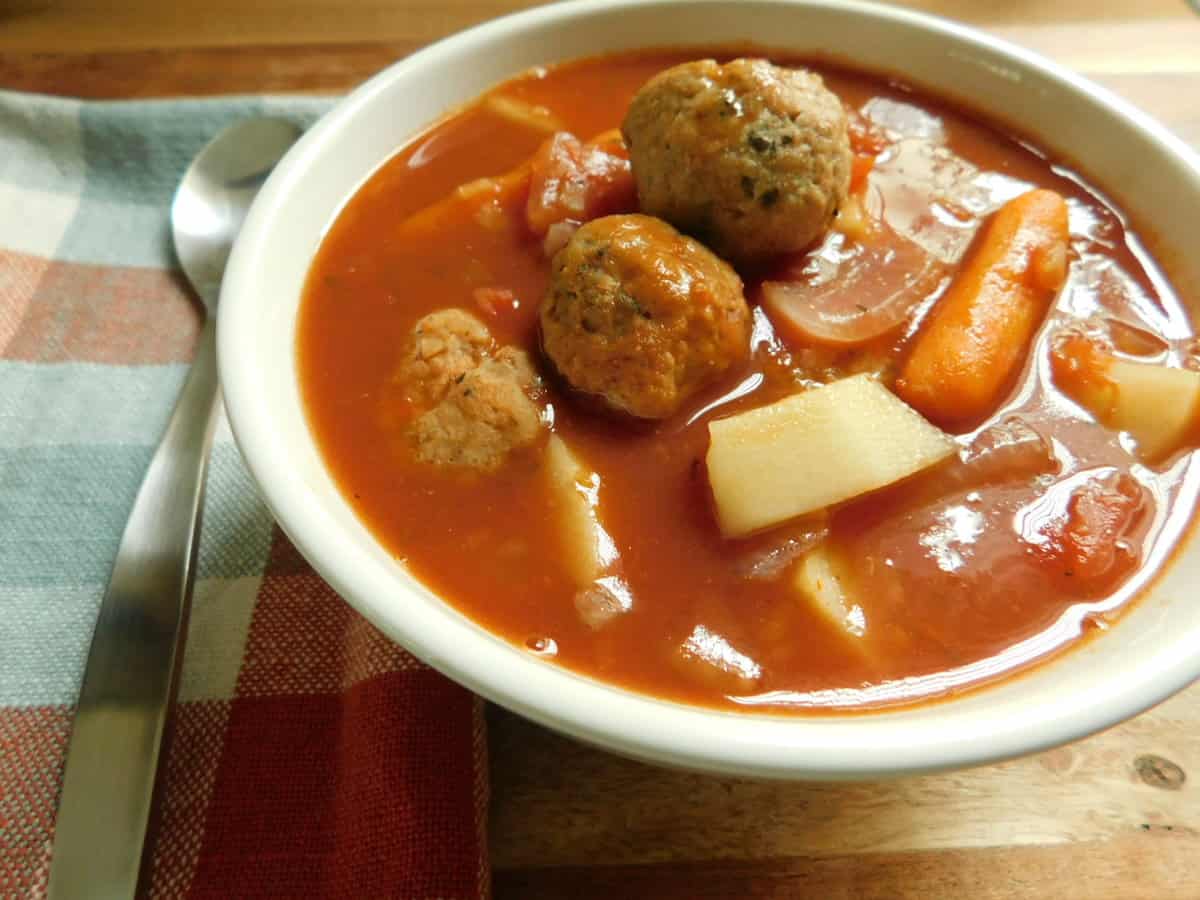 Italian meatball stew in white bowl