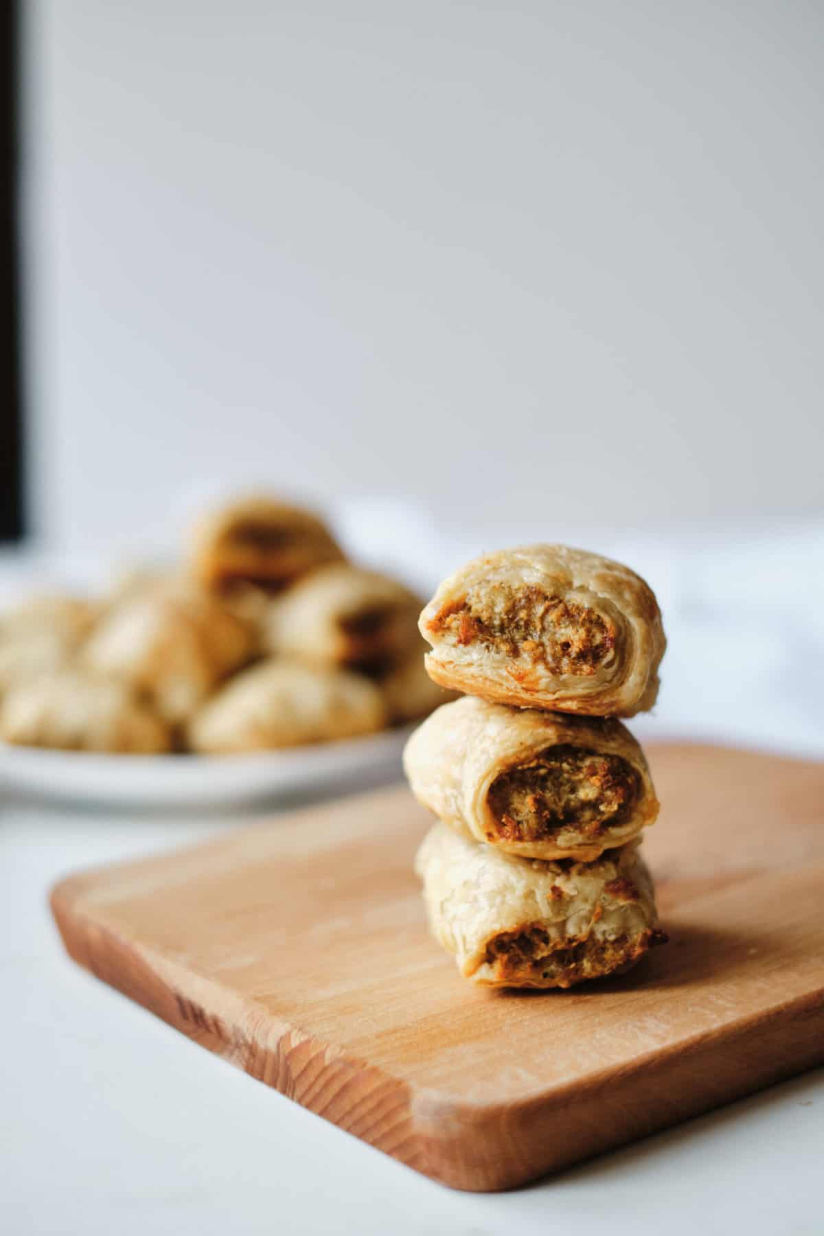 sausage rolls stacked on cutting board