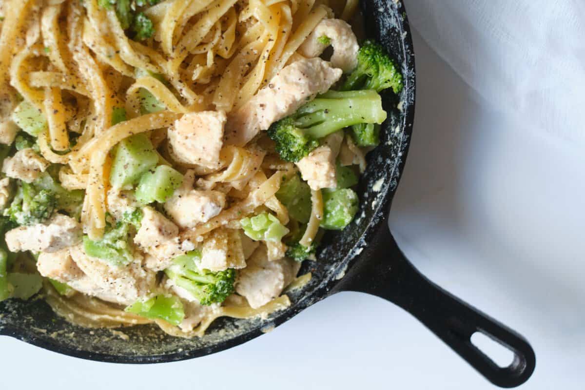 chicken broccoli fettucini alfredo in black frying pan