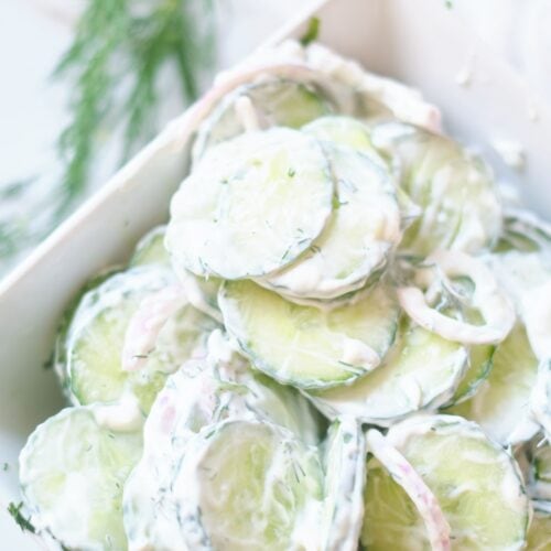 creamy cucumber salad in white serving dish