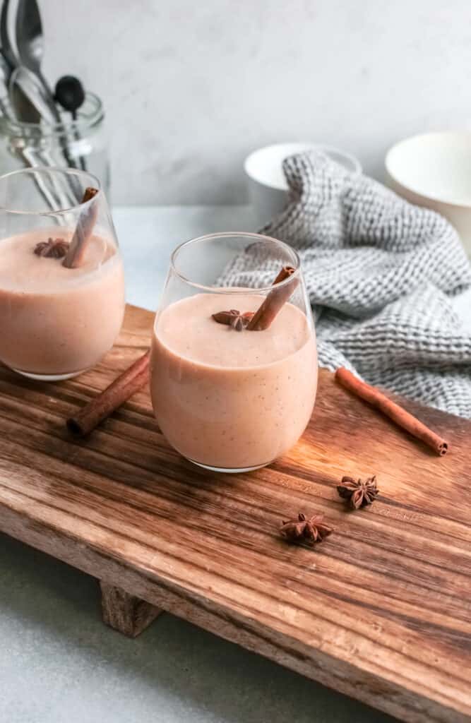 Pumpkin pie smoothie on white glass on cutting board