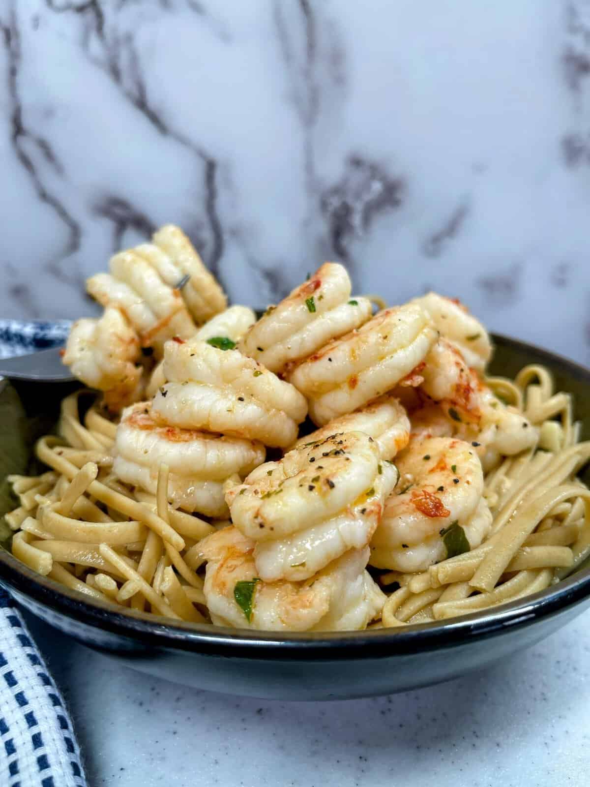 shrimp scampi and noodles in a bowl up close