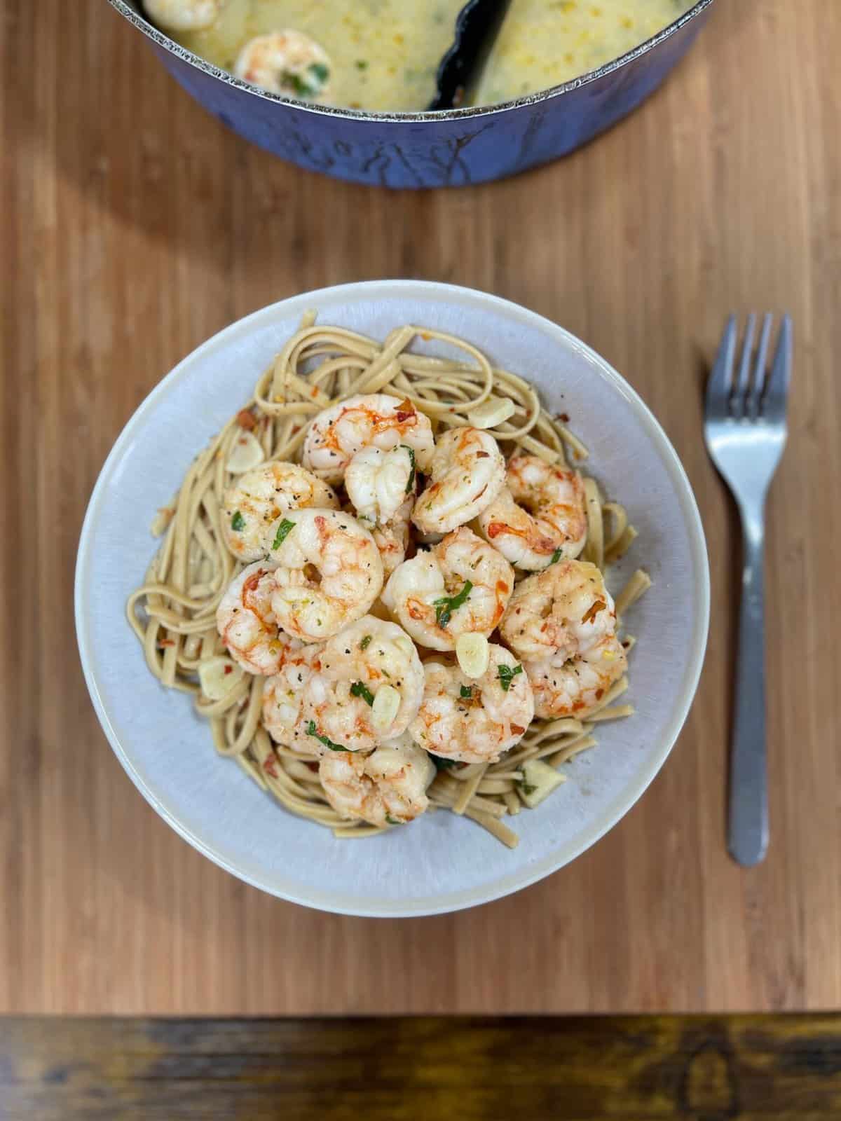 shrimp scampi and noodles in pasta bowl with fork