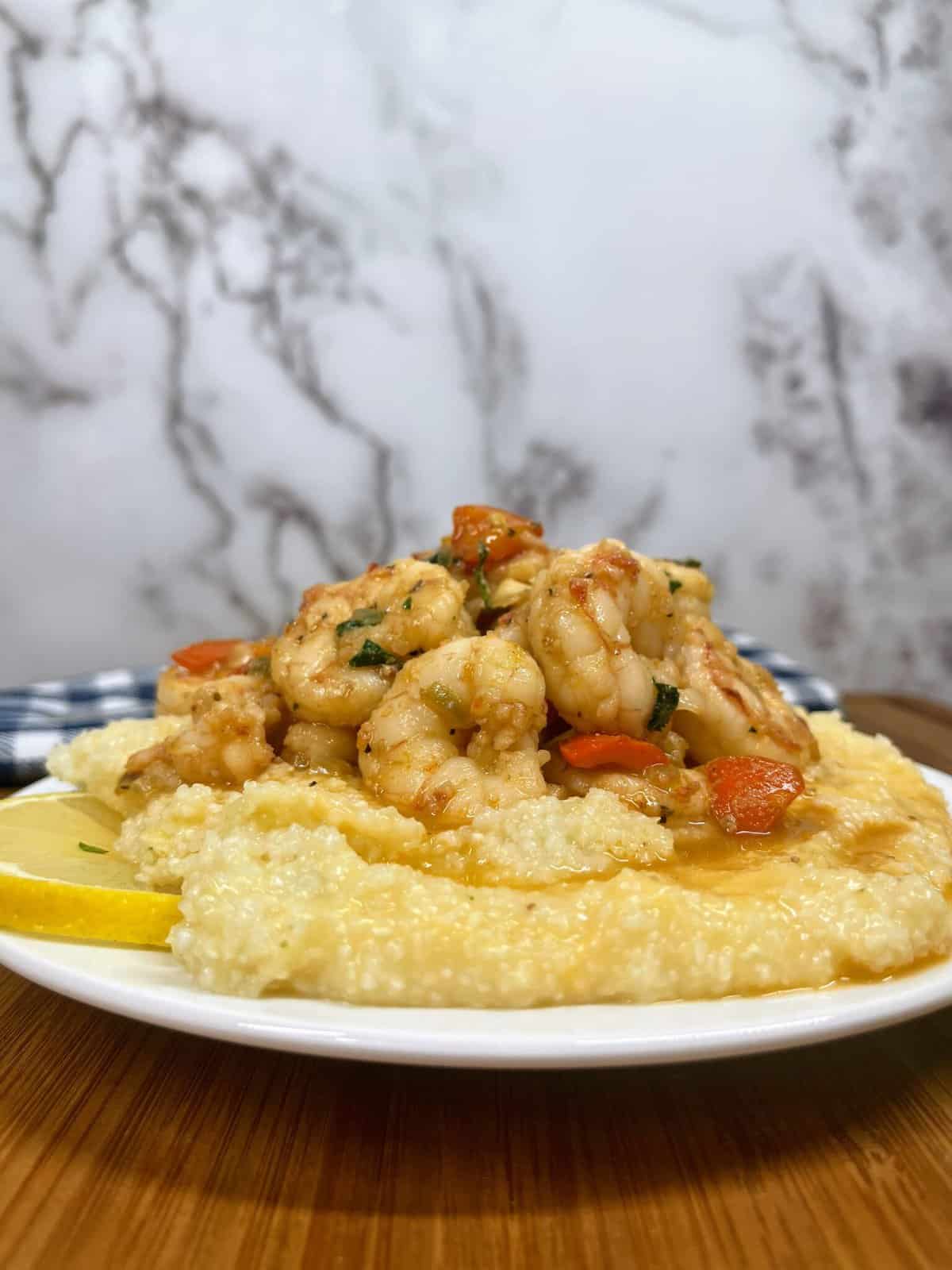 Cooked shrimp and grits on a plate from the side