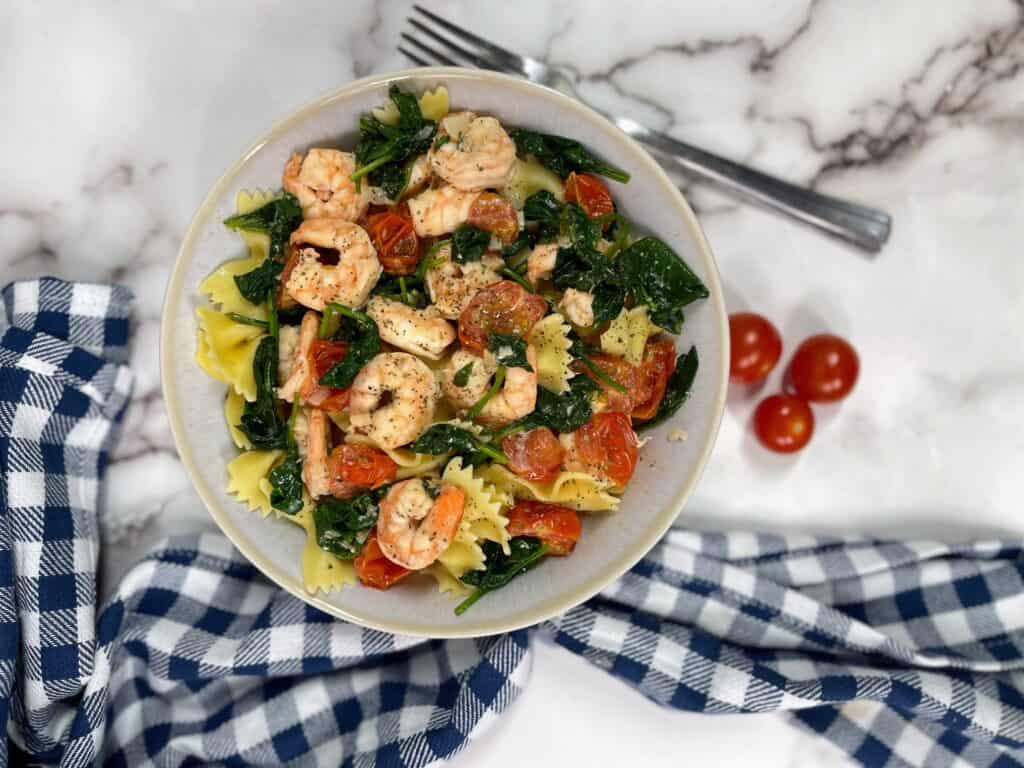 Shrimp cooked over spinach, cherry tomatoes and pasta noodles. 