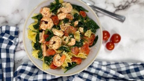Shrimp cooked over spinach, cherry tomatoes and pasta noodles.