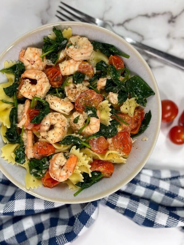 Shrimp cooked over spinach, cherry tomatoes and pasta noodles.