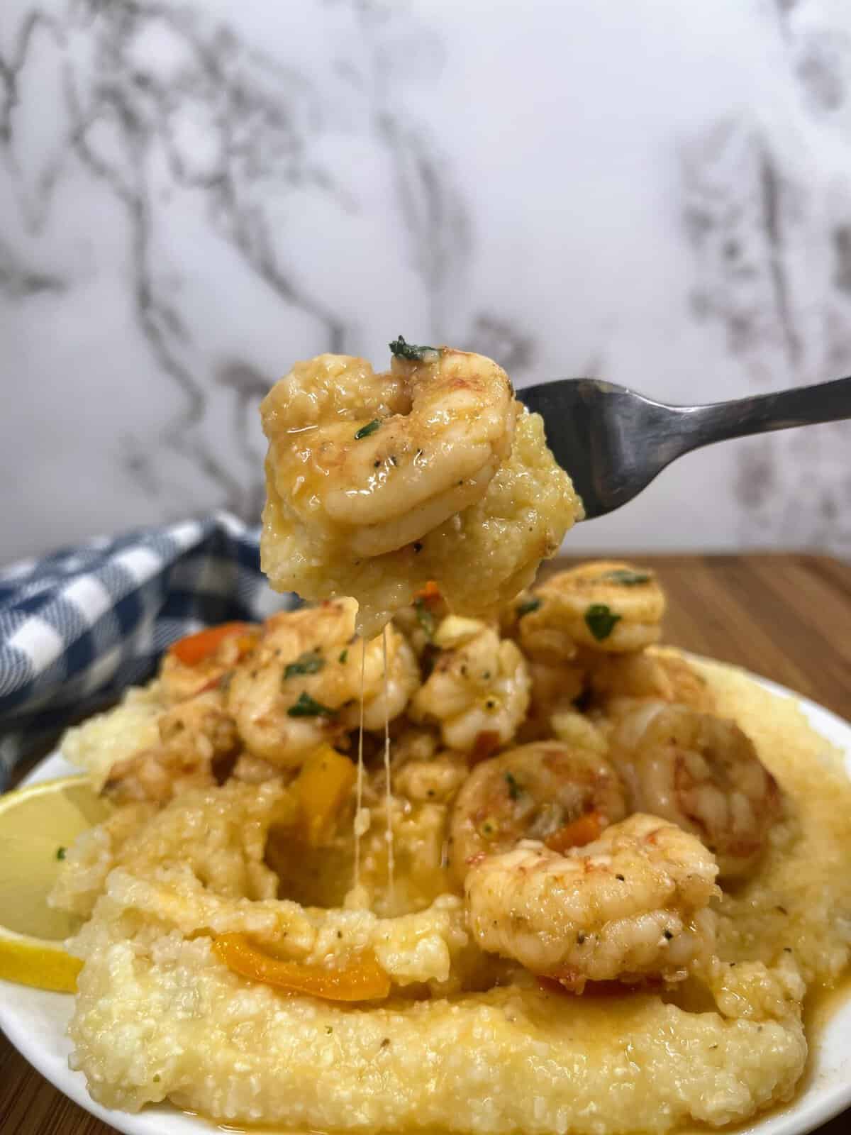 Cooked shrimp and grits on a fork