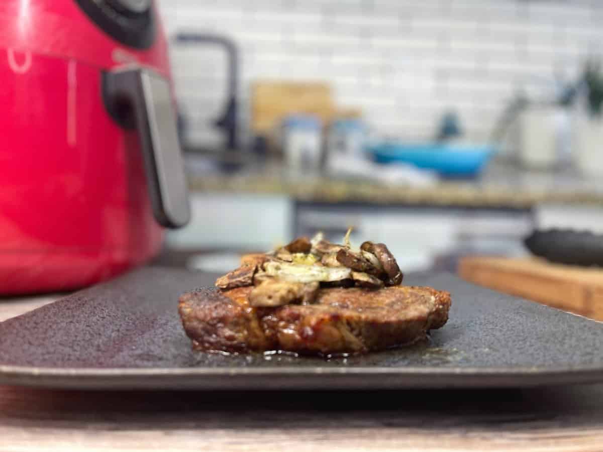 cooked ribeye up close with sautéed mushrooms