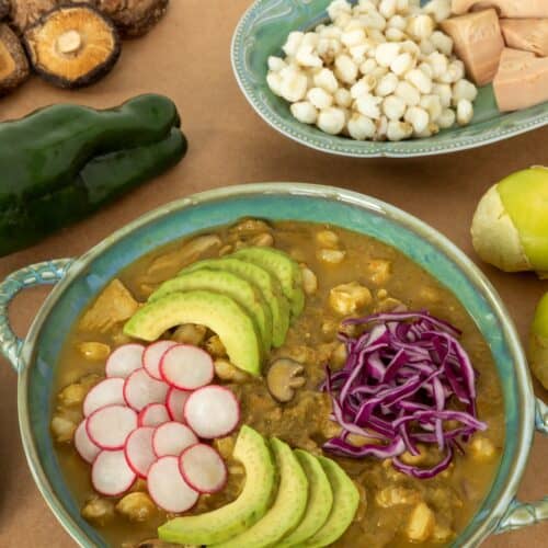 Vegan Pozole verde topped with sliced avocado