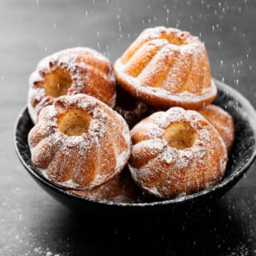 mini bundt cakes in a bowl with powdered sugar