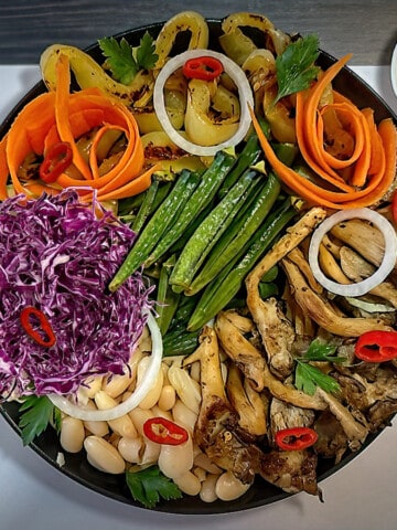 Buddha Bowl featuring okra and purple cabbage i black bowl.
