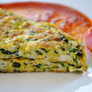 Omelette with spinach and tomatoes sauce.