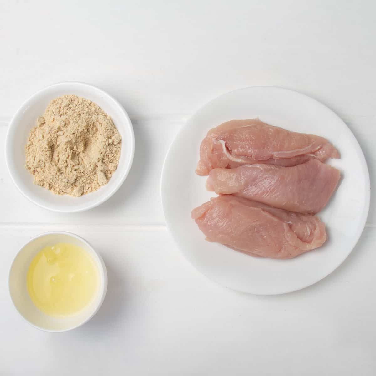 Raw skinless, boneless chicken breasts, egg whites, and Italian breadcrumbs. 