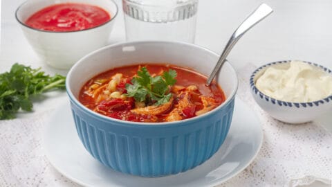 Tomato-based Southwest chicken soup in a bowl with a spoon.