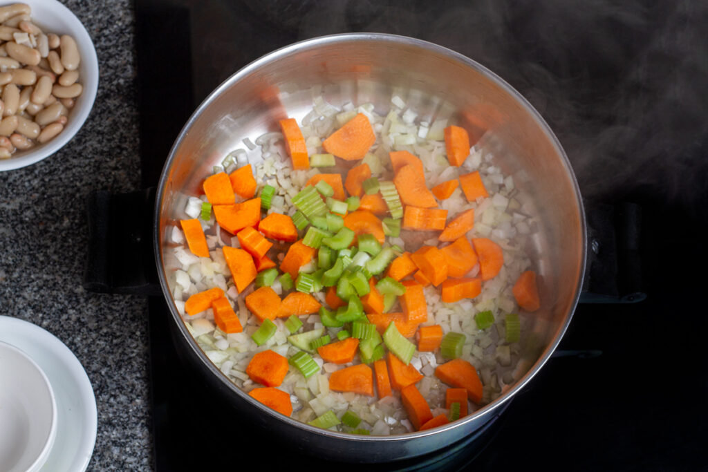 Onion, carrots, celery, garlic, oregano, black pepper, and salt in a pan.