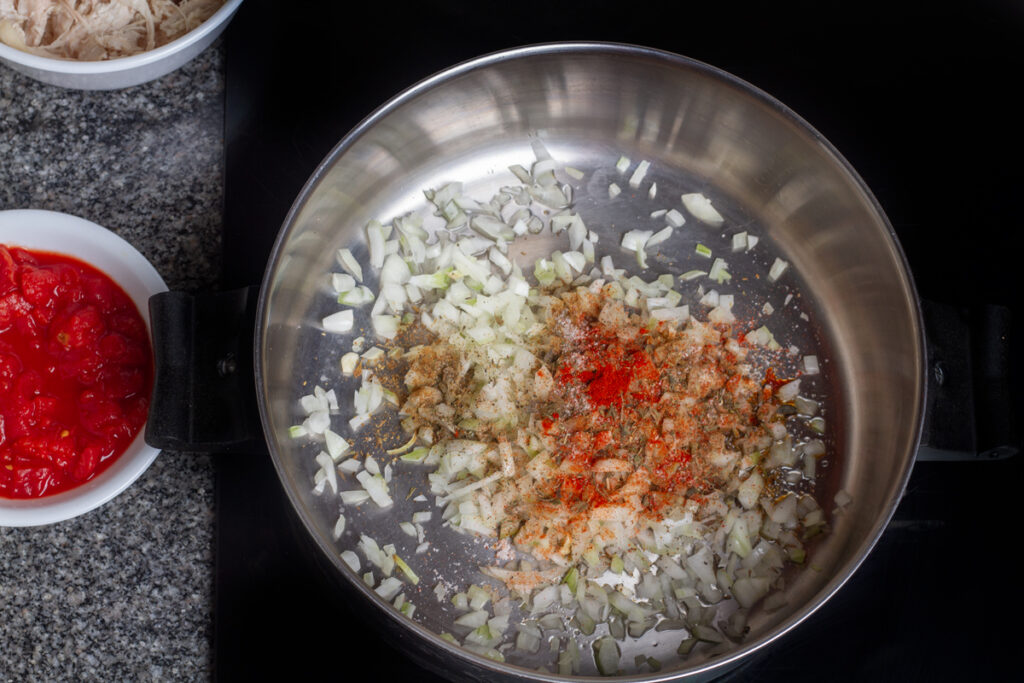 Onion, celery, garlic, and spices cooking in a hot pot. 