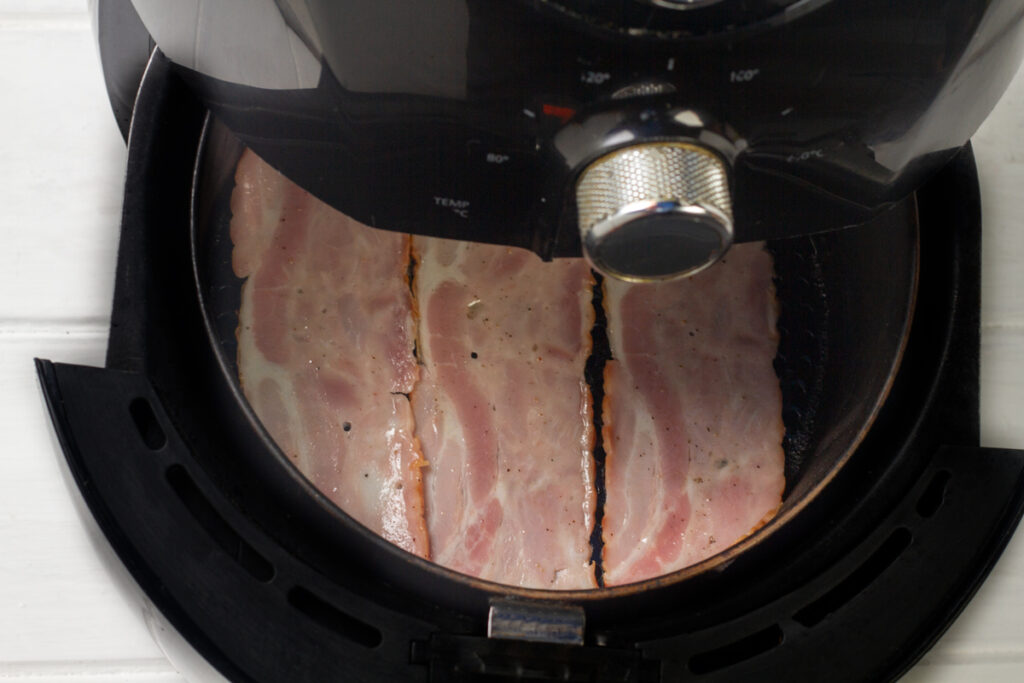 Turkey bacon cooking in an air fryer. 