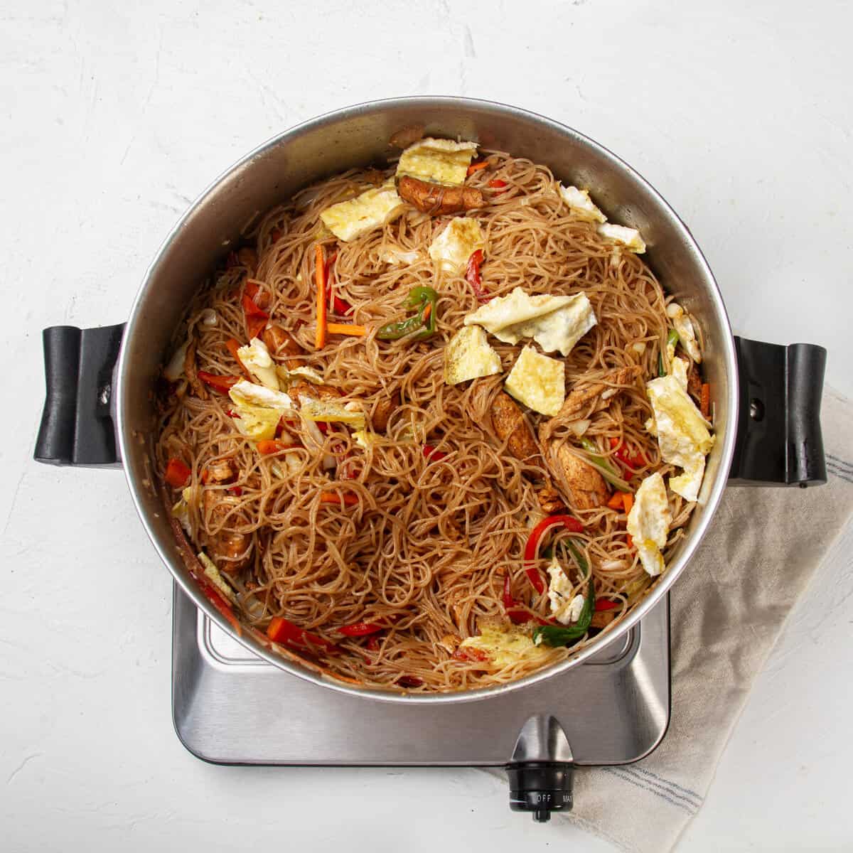 Glass noodles with chicken and vegetables in a pan. 
