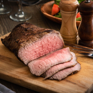 cooked bottom round steak on a cutting board