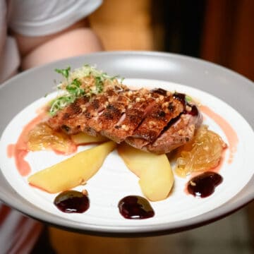 roasted duck fillet served with asian pears on a plate