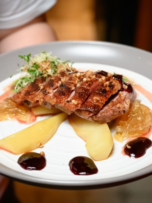 roasted duck fillet served with asian pears on a plate