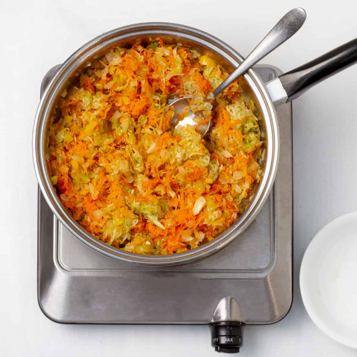 Sauté the chopped onion, garlic, bell pepper, grated carrot, and zucchini