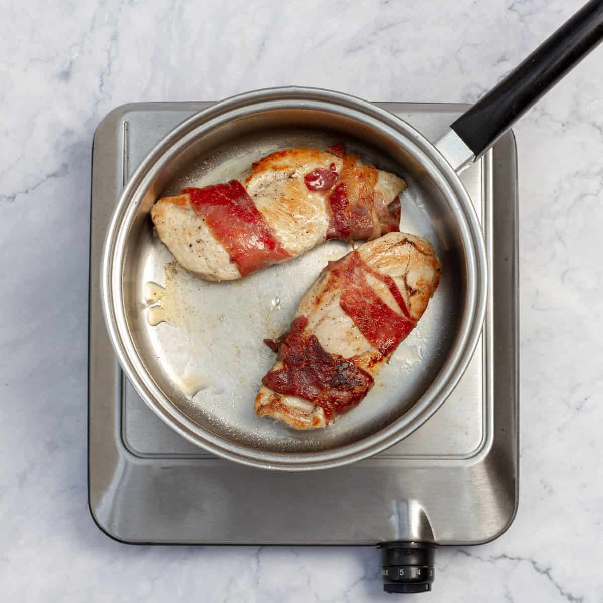 Chicken Saltimbocca cooking in a hot skillet.