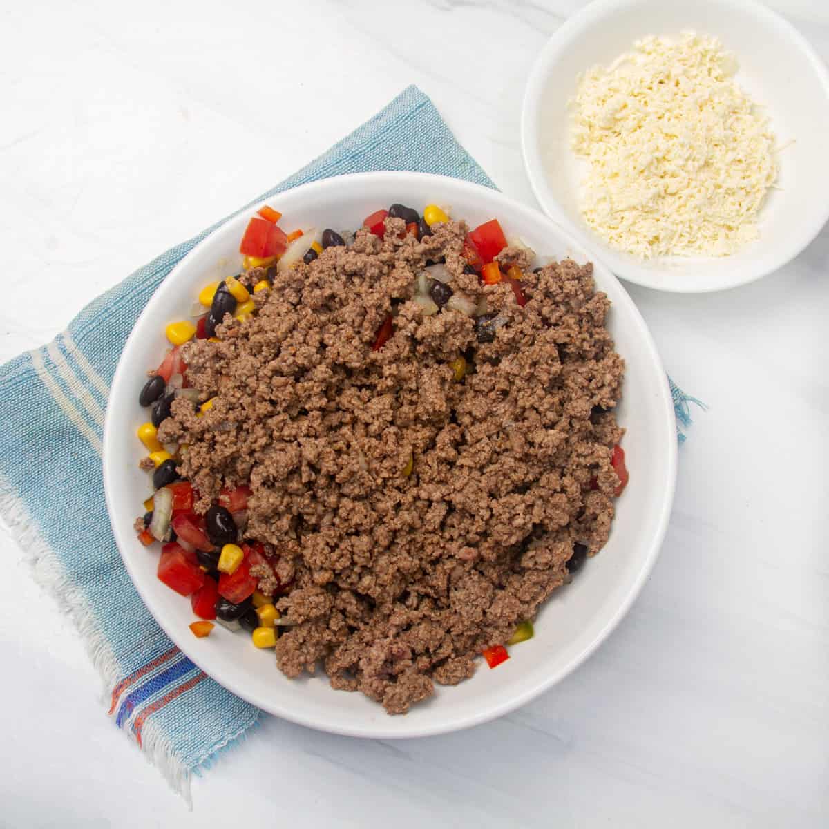 Cooked ground beef added to the mixture of beans and vegetables.
