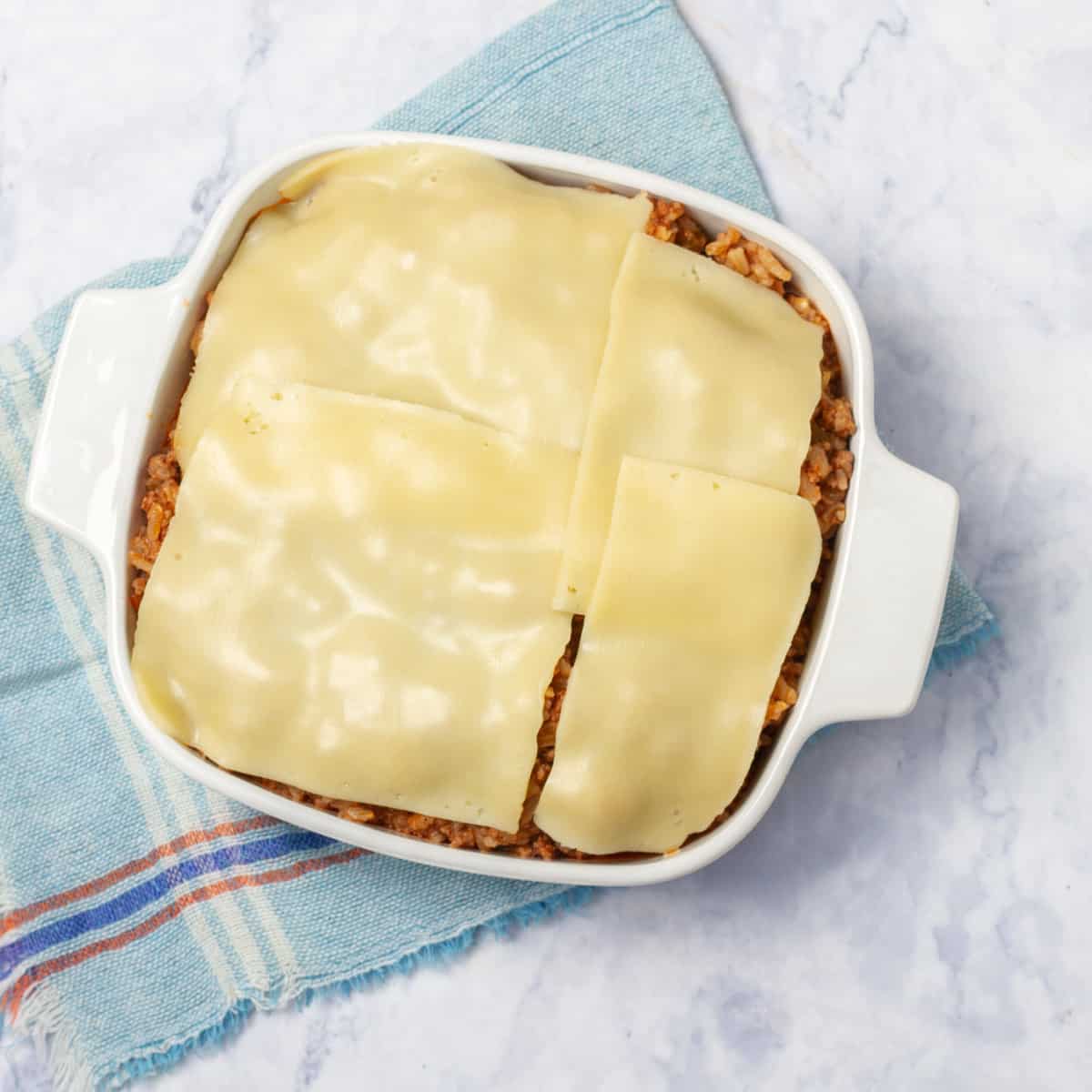 Cooked casserole ingredients assembled in a baking dish with cheese on top.