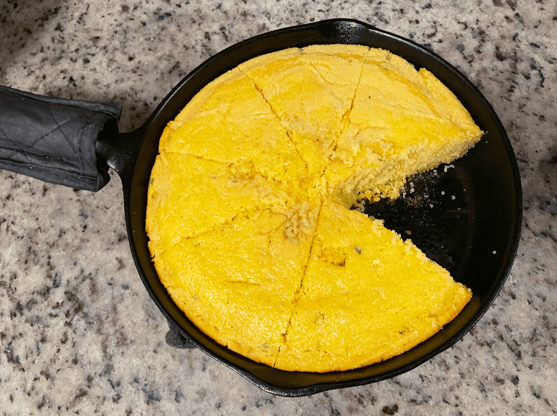 cornbread in cast iron skillet with one piece missing