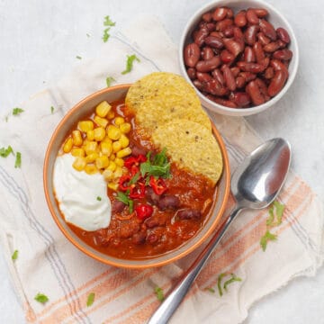 Hearty and nourishing chicken enchilada soup in a bowl, topped with tortilla chips.