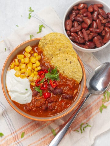 Hearty and nourishing chicken enchilada soup in a bowl, topped with tortilla chips.