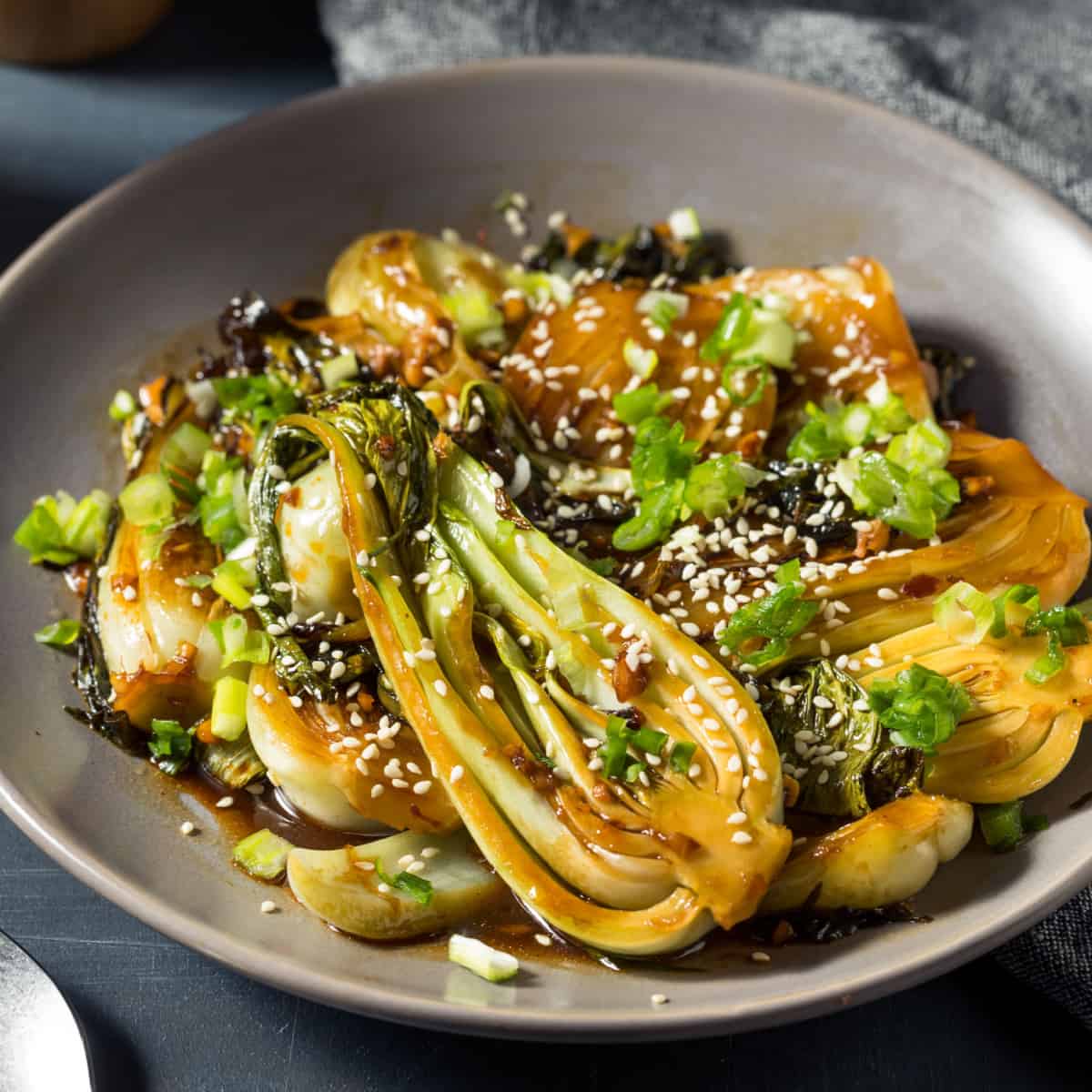 Asian style roast bok choy on beige plate.