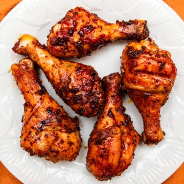 five smoked chicken legs on a white plate