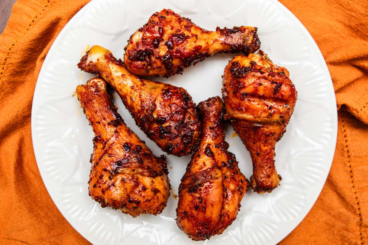 five smoked chicken legs on a white plate