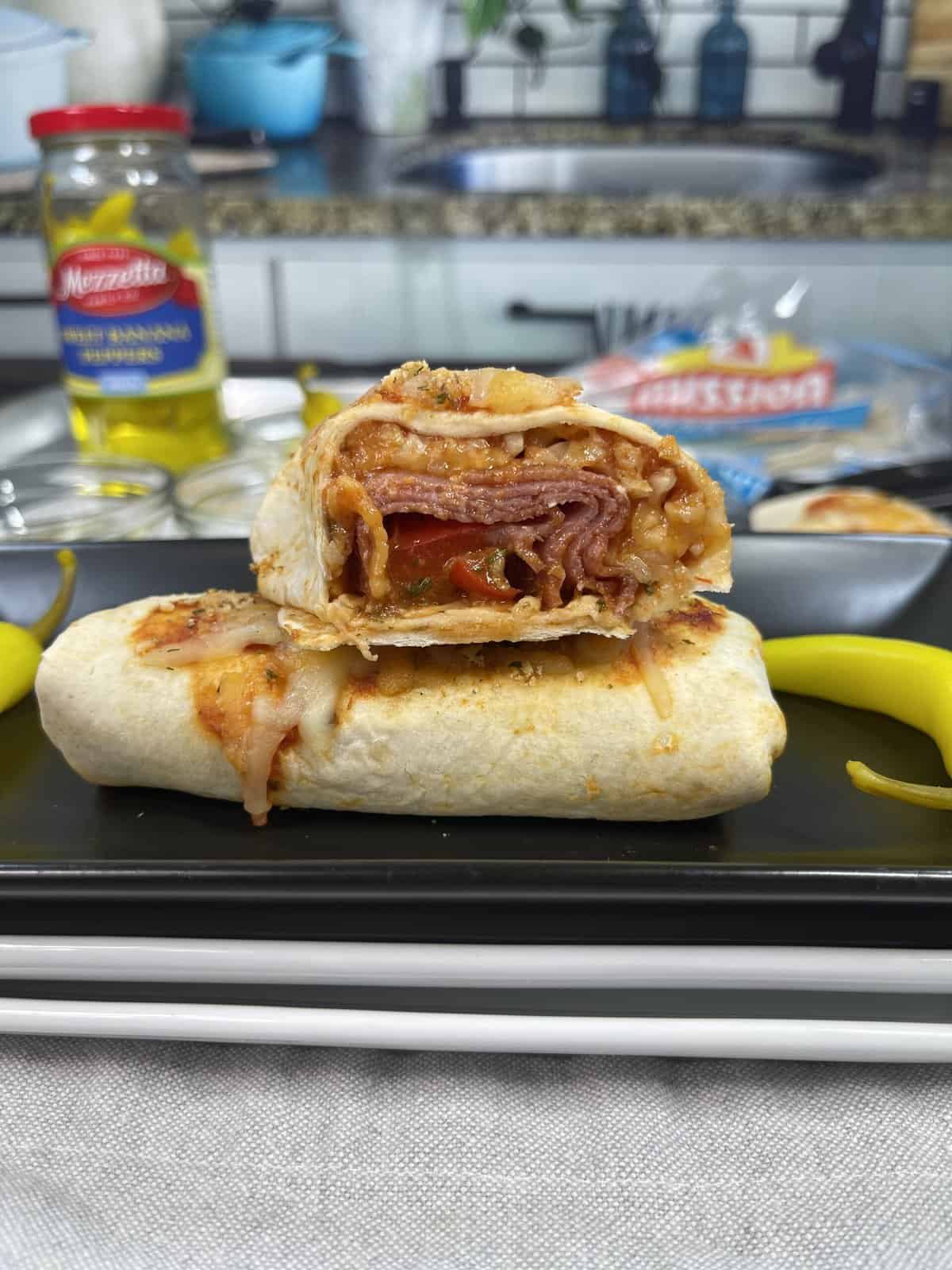 pizza burrito stacked on black plate