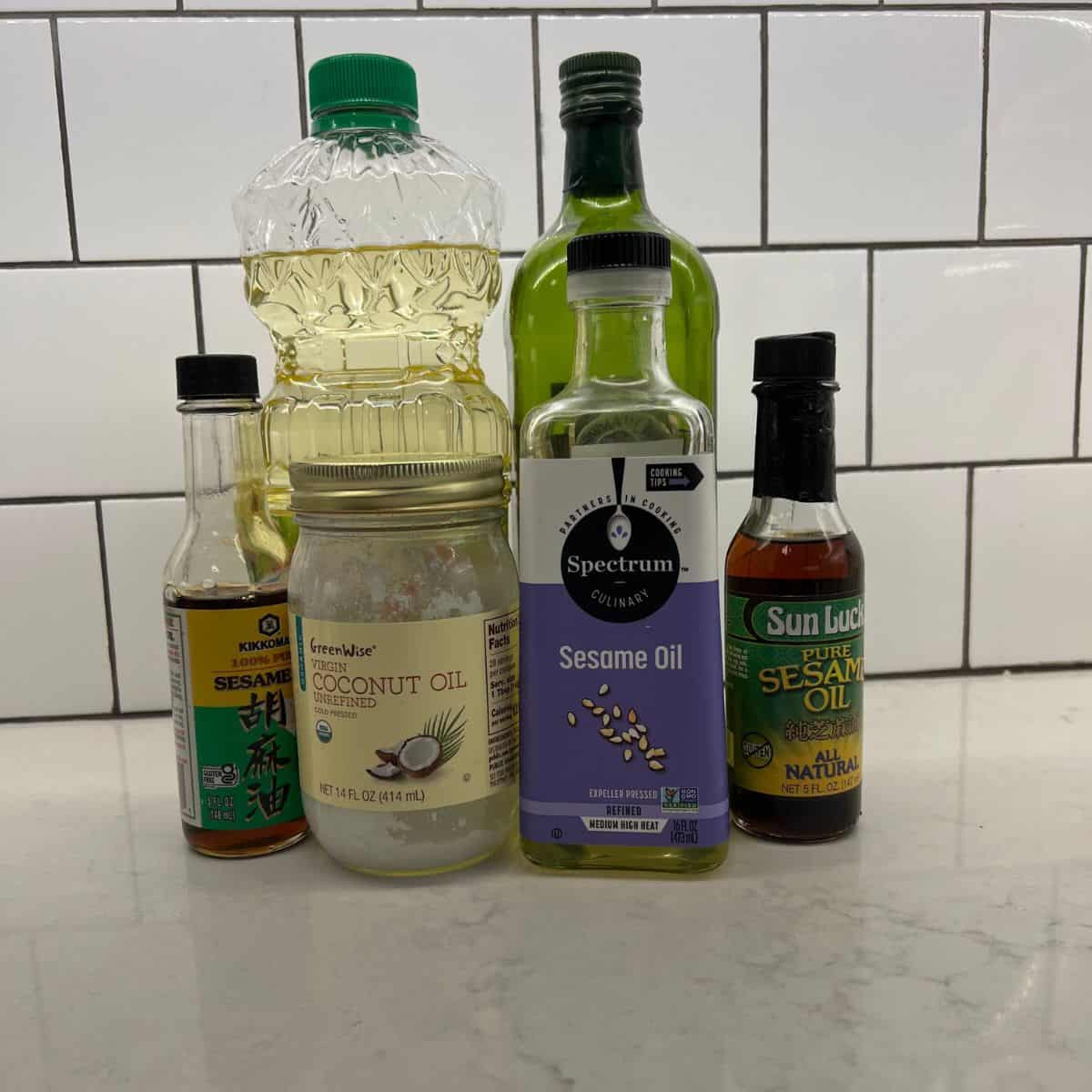 various cooking oils sitting on white counter