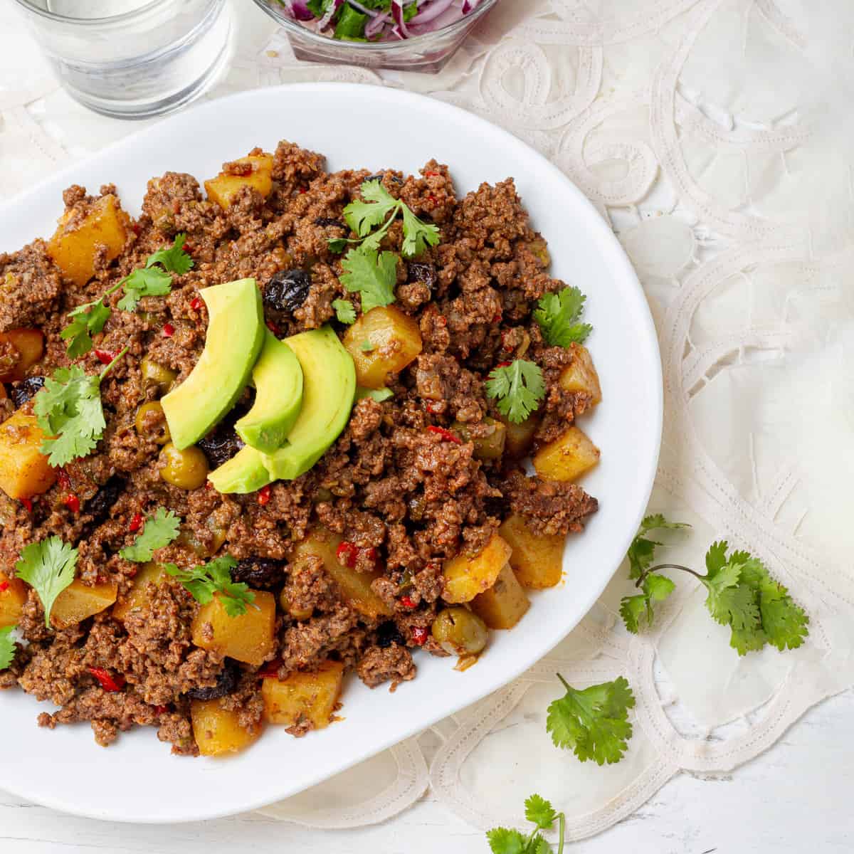 Cuban Picadillo served in a dish with dressing of Avocados slices