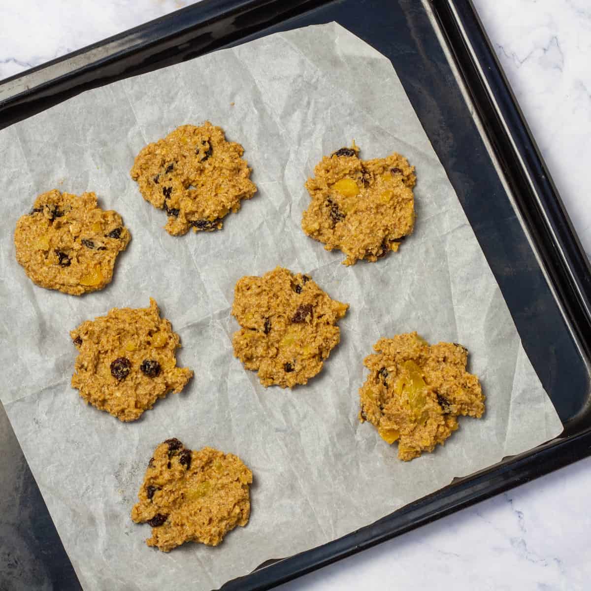Scoop the oat and pumpkin cookie dough onto a parchment-lined baking sheet. 