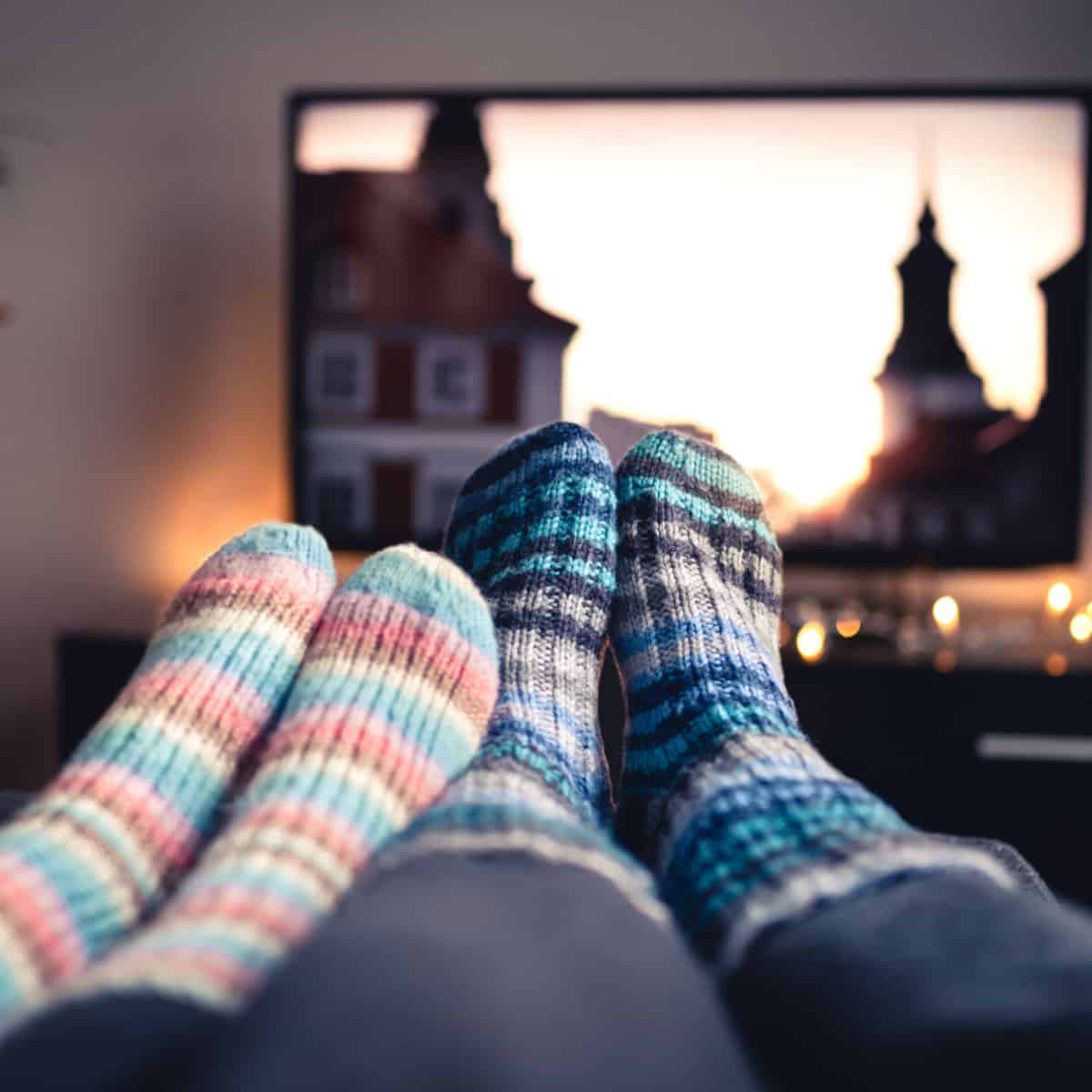 couple watching movie with feet up wearing warm socks