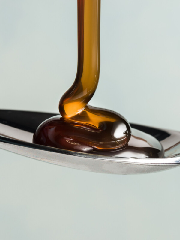 Dark corn syrup pouring on spoon