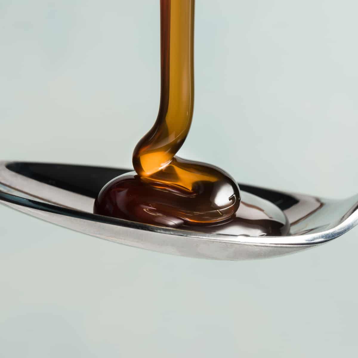 Dark corn syrup pouring on spoon