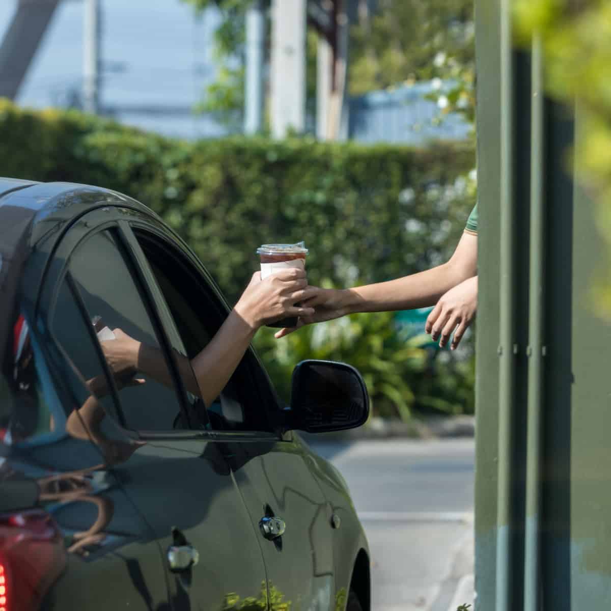Man grabbing coffee at drive thru
